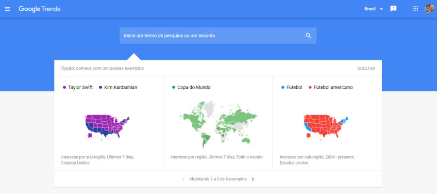 Imagem da página inicial do Google Trends. A imagem possui um menu azul na parte de cima e ao centro a um campo de busca com informações abaixo mostrando mapas e exemplos de pesquisa
