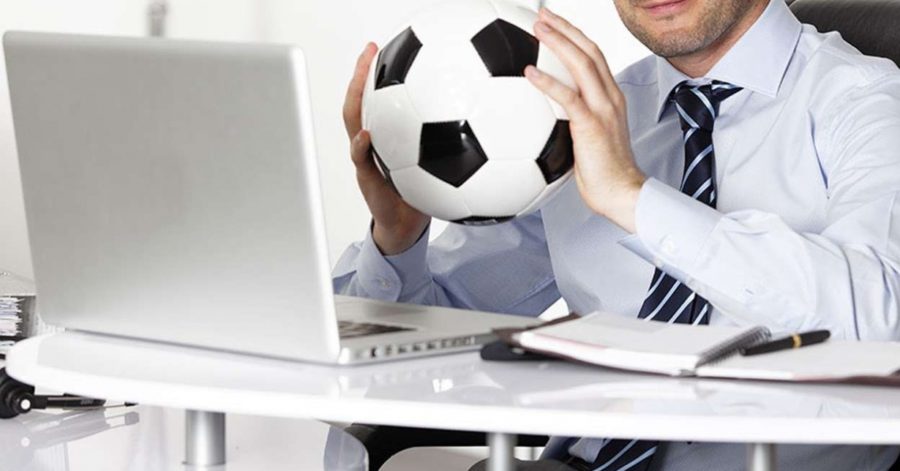 Um home segurando uma bola e pensando nas suas estratégias de vendas para a Copa do Mundo