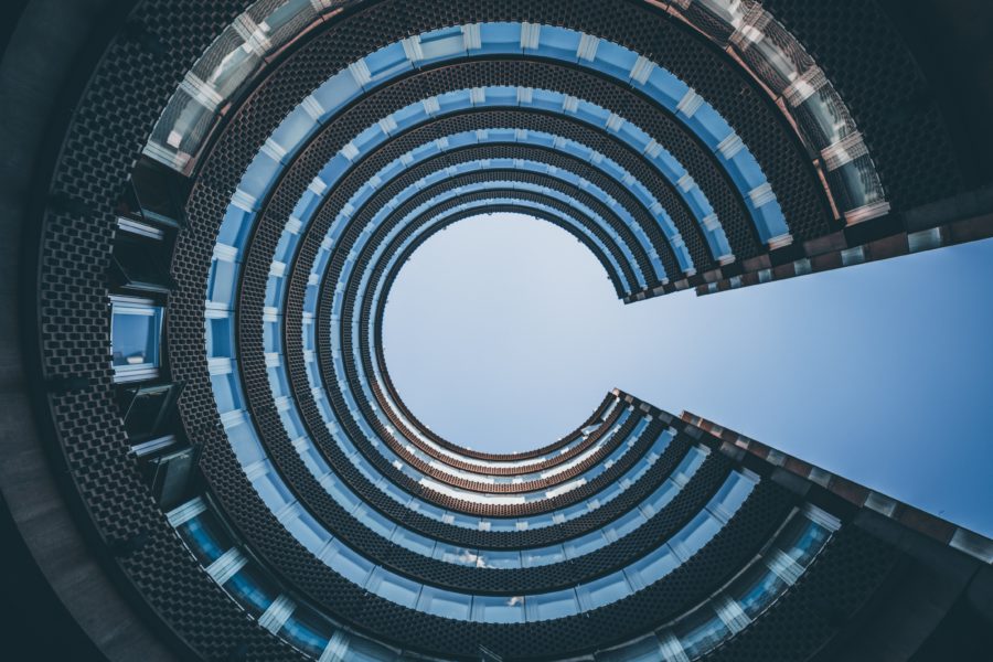 Imagem de um edificio circular visto de baixo, relacionada com tecnologia para imobiliarias