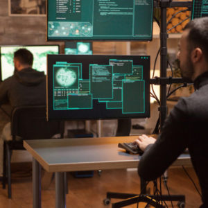 Pessoas utilizando o computador com simbolos relacionados a EDR Security