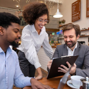 Pessoas trabalhando em um café, imagem relacionada ao employee experience e EmployeeXM